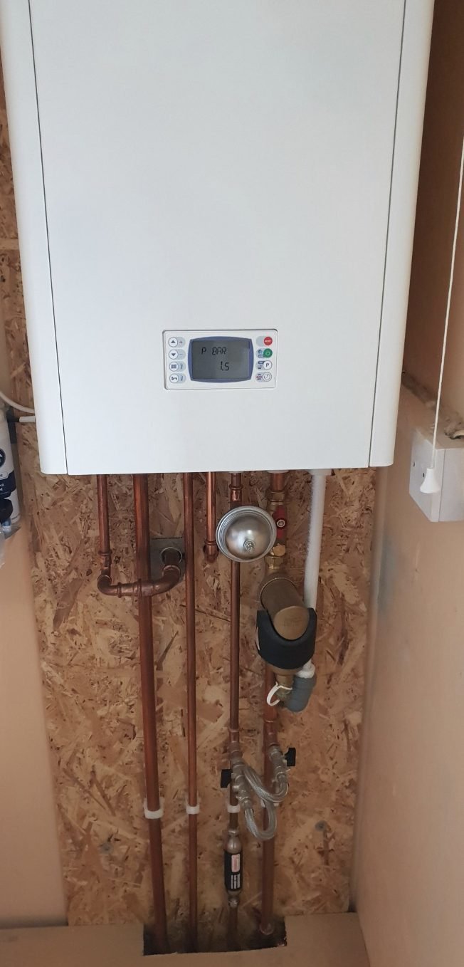 Boiler with copper pipework, magnetic filter and a pressure gauge reading 1.5 bar