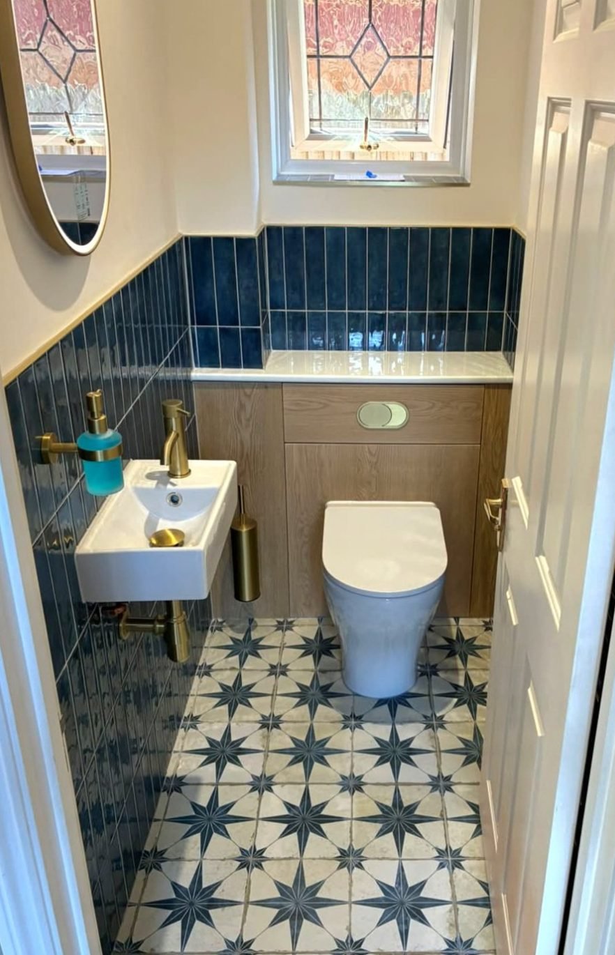 Small downstairs cloakroom with a wall hung basin, gold taps and back to wall WC