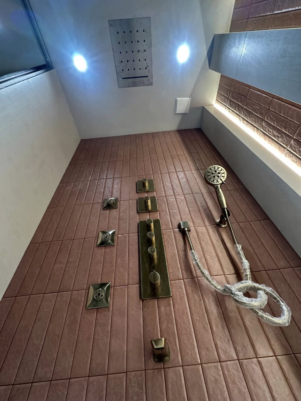 Brushed gold concealed shower system with body jets and a ceiling drencher head